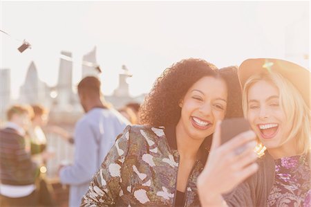 simsearch:6113-07648679,k - Enthusiastic young women taking selfie at rooftop party Stock Photo - Premium Royalty-Free, Code: 6113-08568490