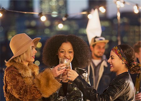simsearch:614-07486947,k - Young women toasting champagne glasses at nighttime rooftop party Foto de stock - Sin royalties Premium, Código: 6113-08568564