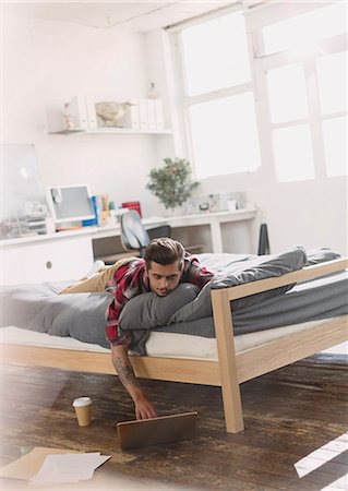 simsearch:625-00801205,k - Young man laying on bed using laptop in apartment Stock Photo - Premium Royalty-Free, Code: 6113-08568568