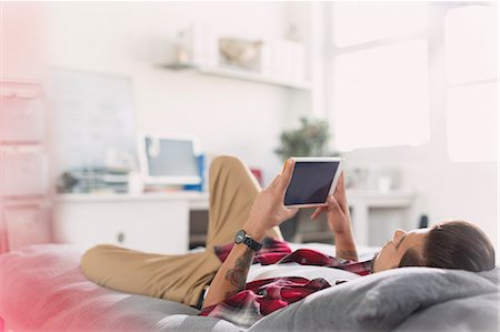 simsearch:625-00801205,k - Young man using digital tablet on bed Stock Photo - Premium Royalty-Free, Code: 6113-08568595