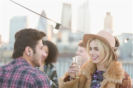 simsearch:6113-07543030,k - Young couple talking and drinking champagne at rooftop party Stock Photo - Premium Royalty-Free, Code: 6113-08568518