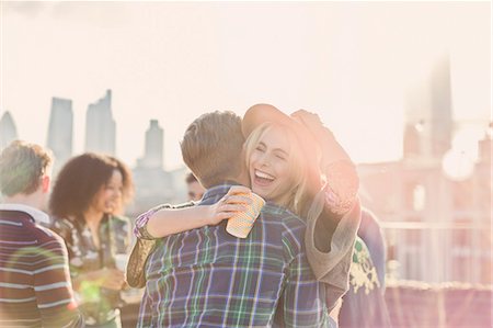 simsearch:6113-07543030,k - Enthusiastic young woman hugging man at rooftop party Stock Photo - Premium Royalty-Free, Code: 6113-08568538