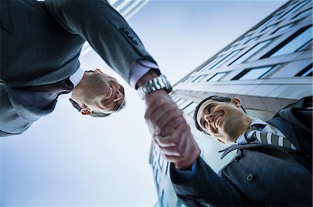 simsearch:6113-06497907,k - Corporate businessmen handshaking below building Stock Photo - Premium Royalty-Free, Code: 6113-08568662