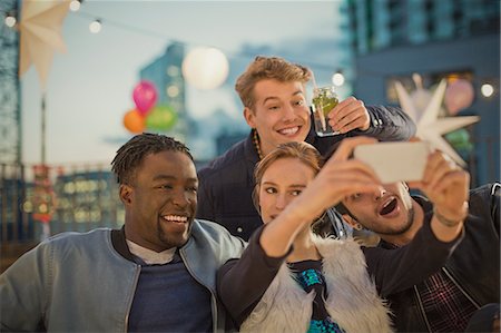 Young adult friends taking selfie at rooftop party Stock Photo - Premium Royalty-Free, Code: 6113-08568605