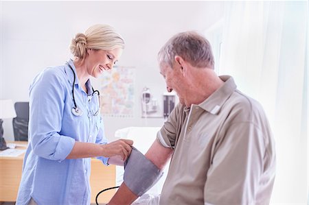 Doctor checking senior man's blood pressure in examination room Photographie de stock - Premium Libres de Droits, Code: 6113-08568775