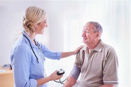 simsearch:6113-07146719,k - Doctor checking senior man's blood pressure in checkup Foto de stock - Sin royalties Premium, Código: 6113-08568720