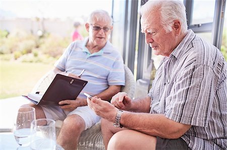 simsearch:6113-06753677,k - Senior men texting with cell phone on patio Stock Photo - Premium Royalty-Free, Code: 6113-08568738