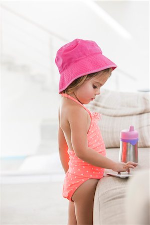 simsearch:614-07768068,k - Toddler girl in bathing suit using digital tablet at sofa Stock Photo - Premium Royalty-Free, Code: 6113-08521294