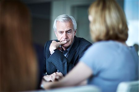 preocupación - Serious senior businessman looking down in meeting Foto de stock - Sin royalties Premium, Código: 6113-08521375