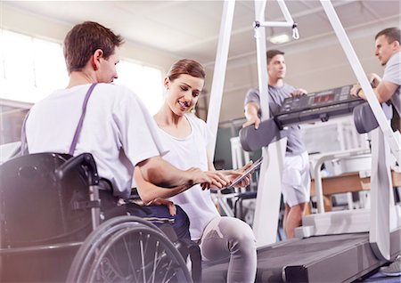 rehabilitation - Physical therapist showing digital tablet to man in wheelchair Stock Photo - Premium Royalty-Free, Code: 6113-08521489