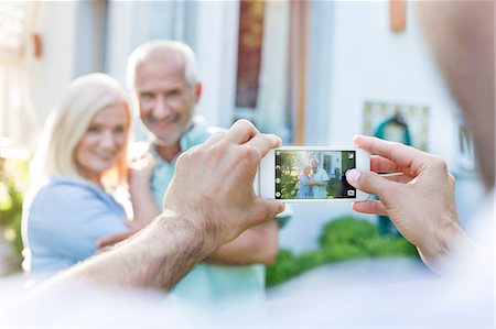simsearch:6113-06498180,k - Man photographing senior couple with camera phone Stock Photo - Premium Royalty-Free, Code: 6113-08521561