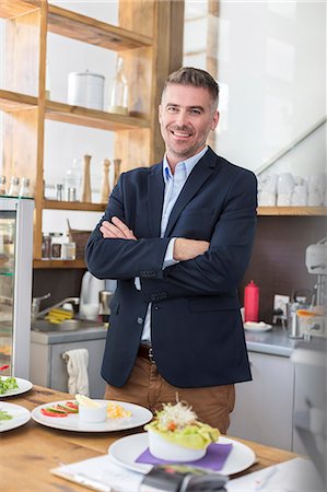 Portrait smiling restaurant owner behind the counter Stock Photo - Premium Royalty-Free, Code: 6113-08521575