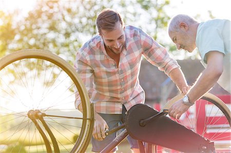 father son study - Father and adult son fixing bicycle Stock Photo - Premium Royalty-Free, Code: 6113-08521514