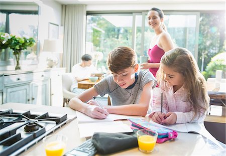 father son study - Mother watching brother and sister doing homework at kitchen counter Stock Photo - Premium Royalty-Free, Code: 6113-08655430