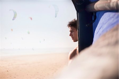 sports events - Pensive man looking away behind kiteboarding kite on sunny beach Photographie de stock - Premium Libres de Droits, Code: 6113-08655578