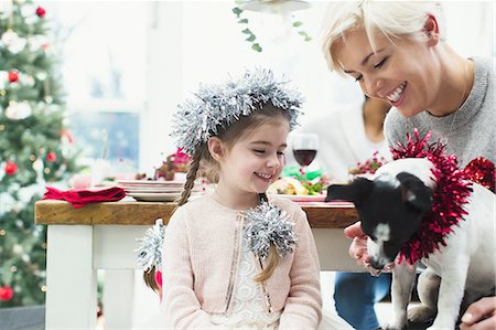 dinner table family - Mother and daughter feeding dog at Christmas dinner Foto de stock - Sin royalties Premium, Código: 6113-08659589