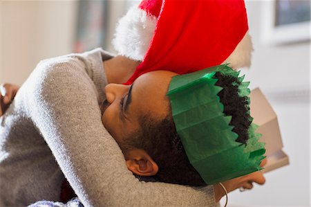 simsearch:649-06716867,k - Affectionate couple in paper crown and Santa hat hugging Stock Photo - Premium Royalty-Free, Code: 6113-08659600