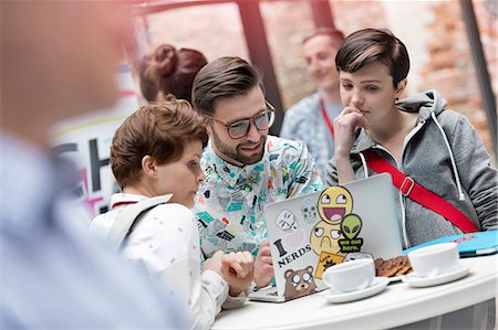 sticker - Man and women using laptop in cafeteria Stock Photo - Premium Royalty-Free, Code: 6113-08698040