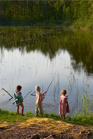 Girls fishing at sunny lakeside Stock Photo - Premium Royalty-Free, Code: 6113-08698072