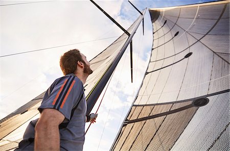 simsearch:614-00602699,k - Man sailing looking up at sail Stock Photo - Premium Royalty-Free, Code: 6113-08698140