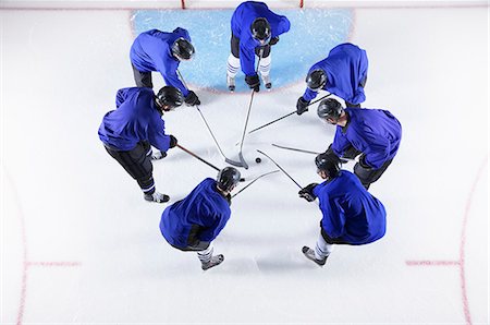 simsearch:6113-08698170,k - Hockey players in blue uniforms huddling around puck on ice Stock Photo - Premium Royalty-Free, Code: 6113-08698175