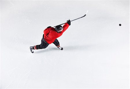 simsearch:6113-08698170,k - Hockey player in red uniform shooting puck on ice Stock Photo - Premium Royalty-Free, Code: 6113-08698185