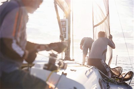 Men adjusting sailing equipment on sailboat Foto de stock - Royalty Free Premium, Número: 6113-08698125