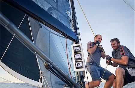 Men sailing pulling rigging equipment on sailboat Stock Photo - Premium Royalty-Free, Code: 6113-08698135