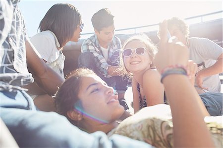 simsearch:6113-08743448,k - Teenage friends hanging out texting on sunny day Stock Photo - Premium Royalty-Free, Code: 6113-08698244