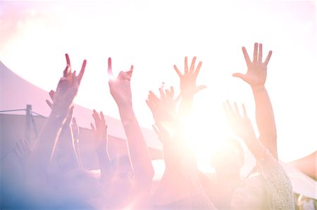 Arms raised cheering at sunny music festival Stock Photo - Premium Royalty-Free, Code: 6113-08698261