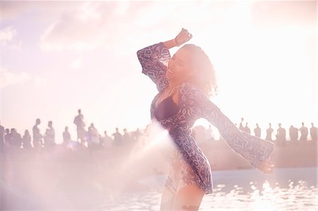 pool party - Young woman dancing at sunny poolside party Stock Photo - Premium Royalty-Free, Code: 6113-08698267