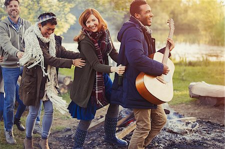 simsearch:6113-08743597,k - Playful friends with guitar dancing in conga line at campsite Stock Photo - Premium Royalty-Free, Code: 6113-08743443