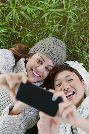 simsearch:6113-08743597,k - Overhead view smiling women taking selfie with camera phone in grass Stock Photo - Premium Royalty-Free, Code: 6113-08743490