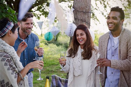 simsearch:6113-08659553,k - Smiling friends drinking champagne at garden party Stock Photo - Premium Royalty-Free, Code: 6113-08743494