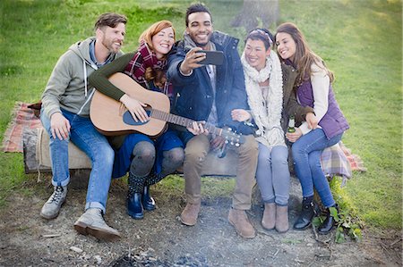 simsearch:6113-08743597,k - Friends with guitar taking selfie with camera phone at campsite Stock Photo - Premium Royalty-Free, Code: 6113-08743499