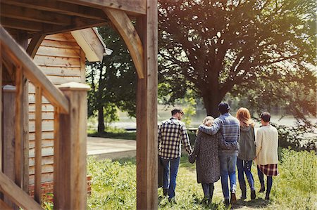 simsearch:6113-07542497,k - Friends walking outside lakeside cabin Stock Photo - Premium Royalty-Free, Code: 6113-08743401