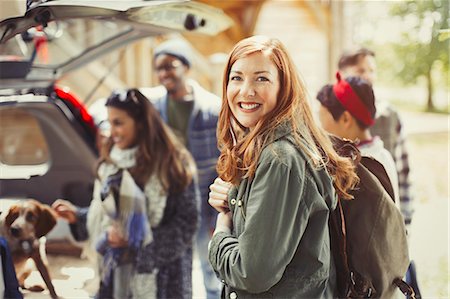 simsearch:6113-08743597,k - Portrait smiling hiker holding backpack with friends at back of car Stock Photo - Premium Royalty-Free, Code: 6113-08743409