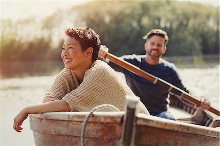 Smiling couple canoeing on sunny lake Stock Photo - Premium Royalty-Free, Code: 6113-08743414