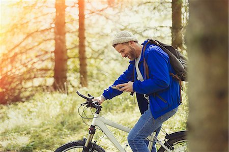 simsearch:6113-08743448,k - Man mountain biking texting with cell phone in woods Stock Photo - Premium Royalty-Free, Code: 6113-08743437