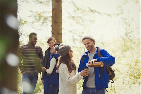 simsearch:6113-07147024,k - Smiling friends hiking pouring coffee from insulated drink container in woods Stock Photo - Premium Royalty-Free, Code: 6113-08743567