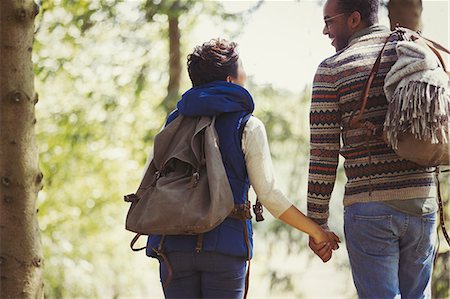 simsearch:6113-07147024,k - Couple with backpacks holding hands hiking in woods Stock Photo - Premium Royalty-Free, Code: 6113-08743591