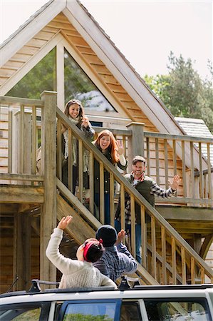 simsearch:649-06532718,k - Friends on stairs waving to friends in car outside sunny cabin Stock Photo - Premium Royalty-Free, Code: 6113-08743505