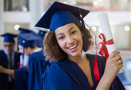 simsearch:6113-07791483,k - Portrait smiling female college graduate in cap and gown holding diploma Stock Photo - Premium Royalty-Free, Code: 6113-08769662