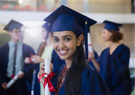 simsearch:6113-07791483,k - Portrait smiling female college student in cap and gown with diploma Stock Photo - Premium Royalty-Free, Code: 6113-08769665
