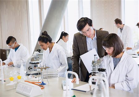 simsearch:649-07118442,k - Science professor helping college student conducting scientific experiment in science laboratory classroom Stock Photo - Premium Royalty-Free, Code: 6113-08769679
