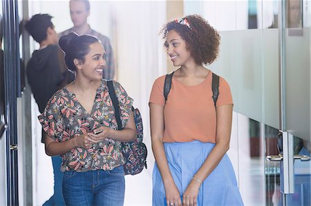 simsearch:614-06973669,k - Smiling female college students walking in corridor Stock Photo - Premium Royalty-Free, Code: 6113-08769689