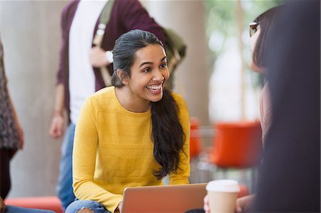 Smiling female college students with coffee and laptop Stock Photo - Premium Royalty-Free, Code: 6113-08769629