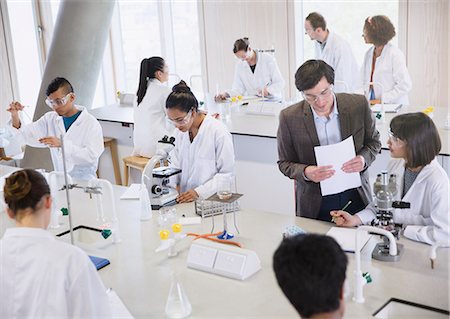 simsearch:649-07118442,k - Science professor and college students using microscopes in science laboratory classroom Stock Photo - Premium Royalty-Free, Code: 6113-08769638