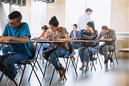 Professor watching college students taking test in classroom Stock Photo - Premium Royalty-Free, Code: 6113-08769700