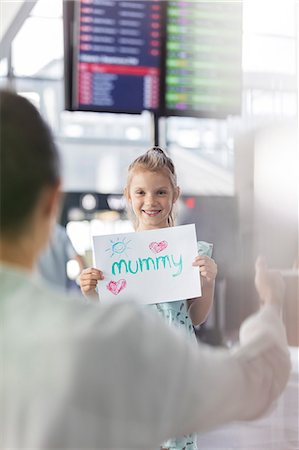 reuniting - Daughter with welcome sign welcoming mother at airport Stock Photo - Premium Royalty-Free, Code: 6113-08784185